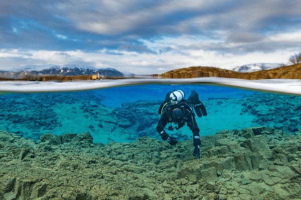 a scuba diver is swimming in a body of water at Garður in Iceland.