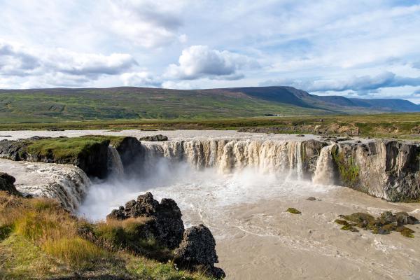 Godafoss watefall on sunny day surrounded by greenery