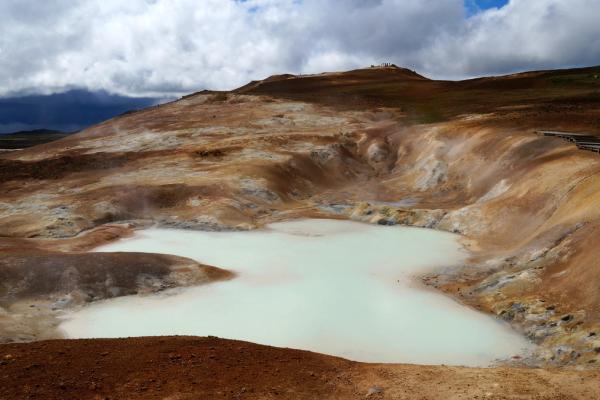 a small white lake in the middle of a dirt field at leirhnjúkur in Iceland.