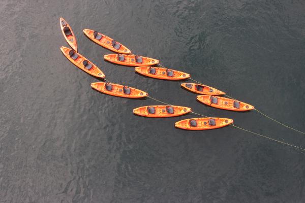 kayaks de color naranja atados unos a otros, flotando sobre el agua