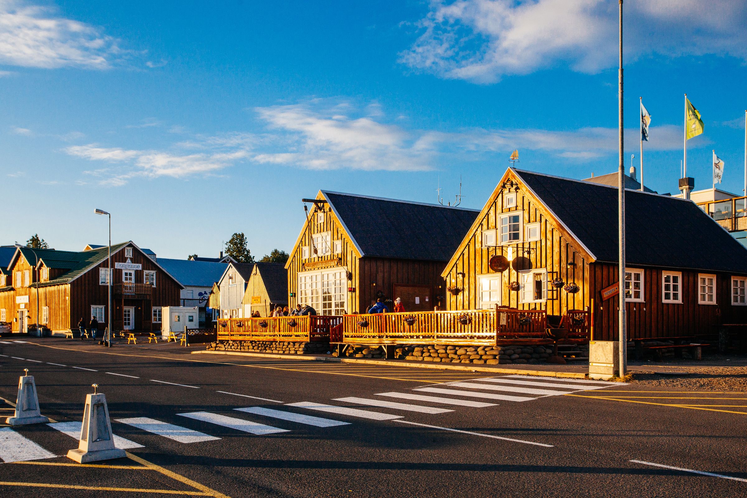 une rangée de maisons en bois côte à côte au bord d'une route, Husavik