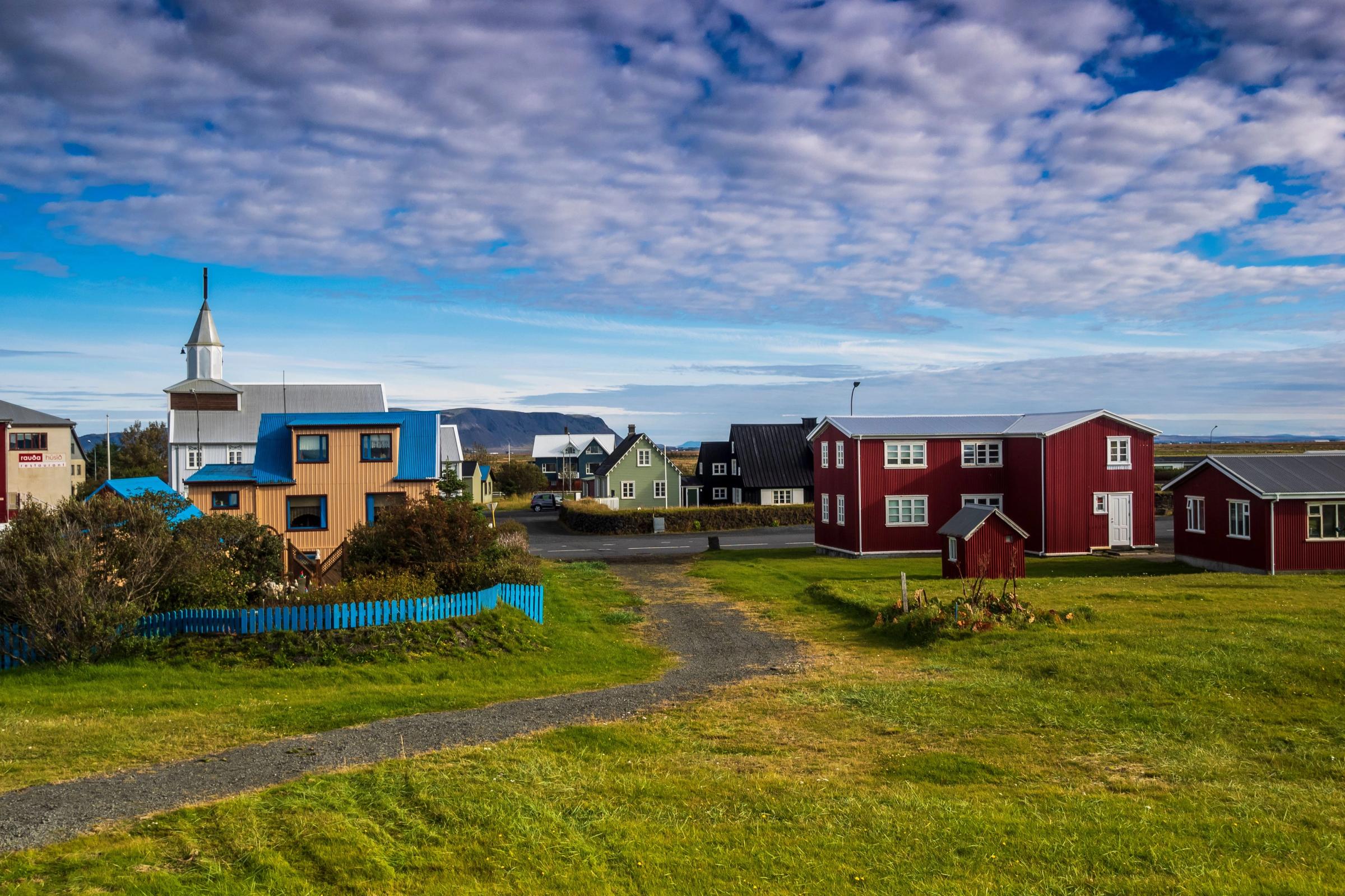 Pequeño pueblo con casas de colores y un caminito rodeado de césped
