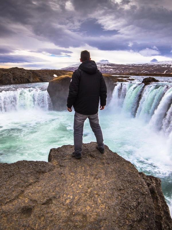 Man admiring Godafoss Waterfall in May