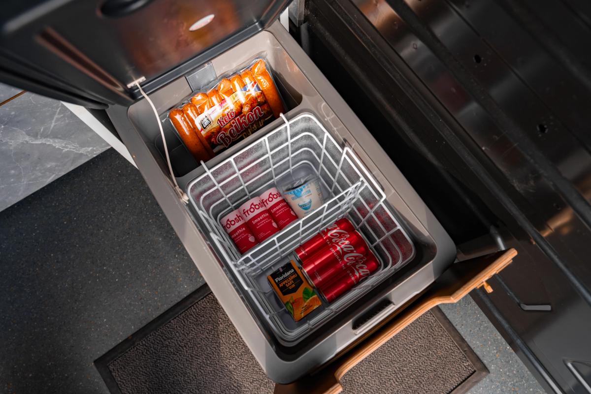 Nevera de apertura superior sobre una bandeja extraíble, con una cesta metálica para guardar bebidas y alimentos