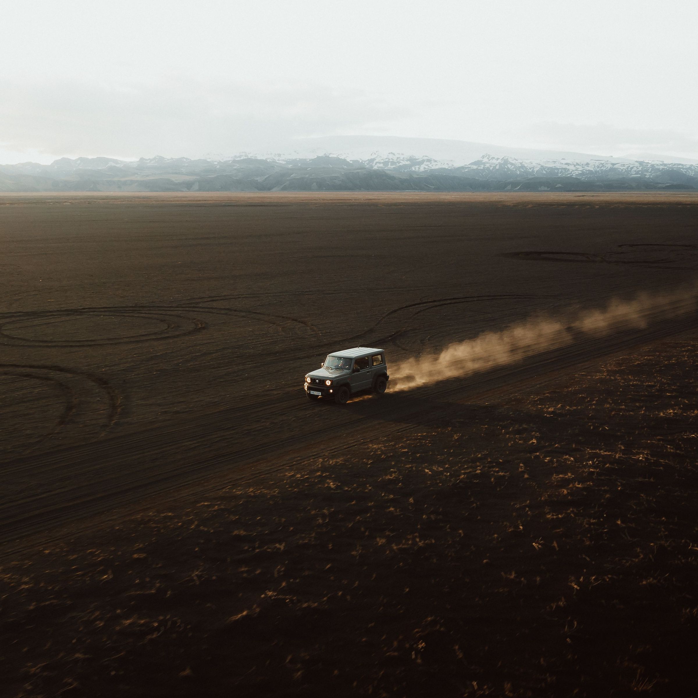 Coche por una carretera de grava en Islandia