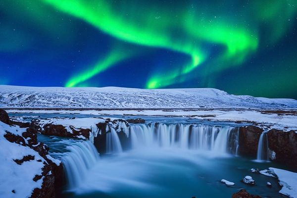 Goðafoss completamente nevada bajo la aurora boreal