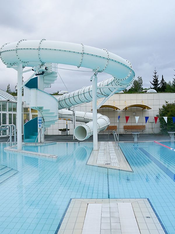 there is a water slide in the middle of a swimming pool .