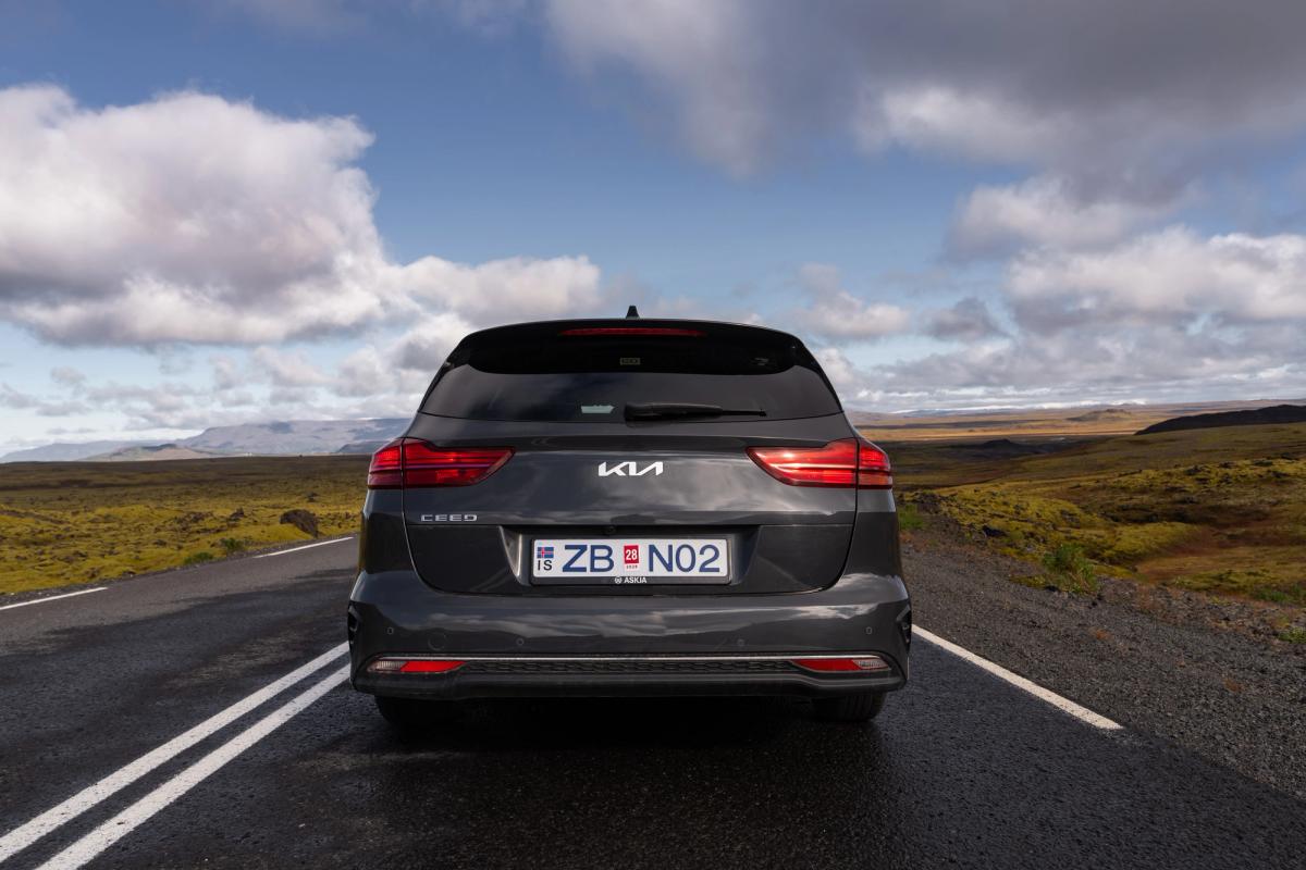 Ceed Wagon trasera en autopista Vista trasera de un Kia Ceed familiar en una carretera de circunvalación asfaltada que atraviesa un paisaje abierto cubierto de musgo