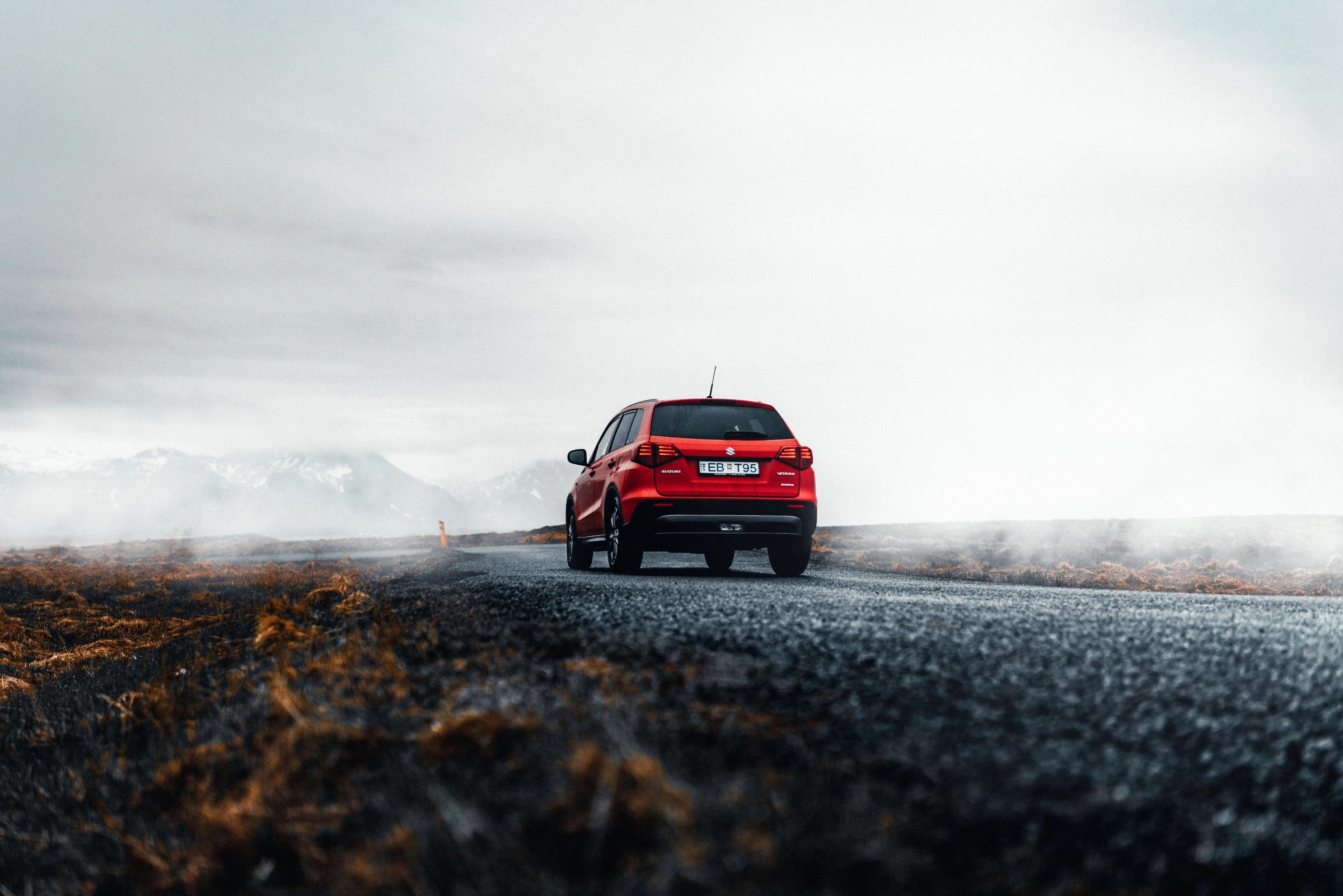 Red Suzuki Vitara on a paved road 