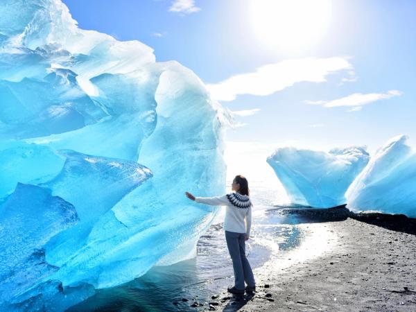 Mujer tocando un iceberg en Islandia