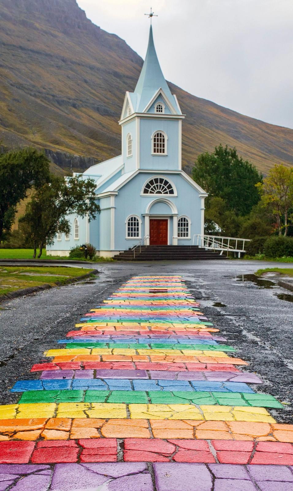 un camino de ladrillos de colores de arcoíris conduce a una iglesia
