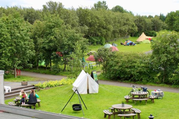 a campsite with tents an wooden picnic tables