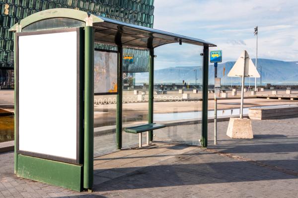 a bus stop with a billboard and a bench .