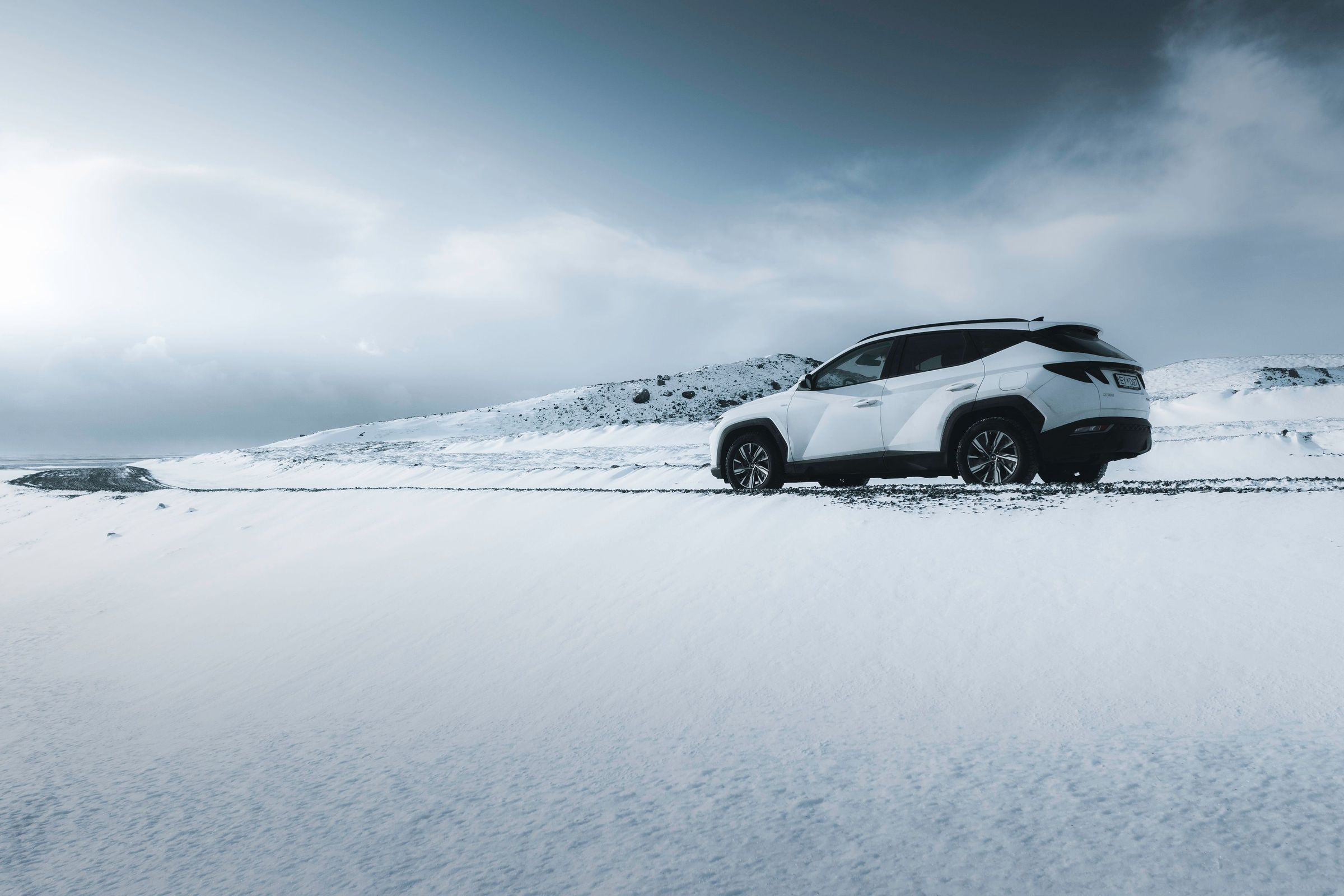 4x4 Hyndai Tucson Iceland White 4x4 Tucson rental car driving in a snowy Iceland