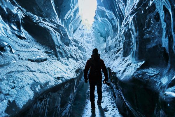 a man is walking through an ice cave