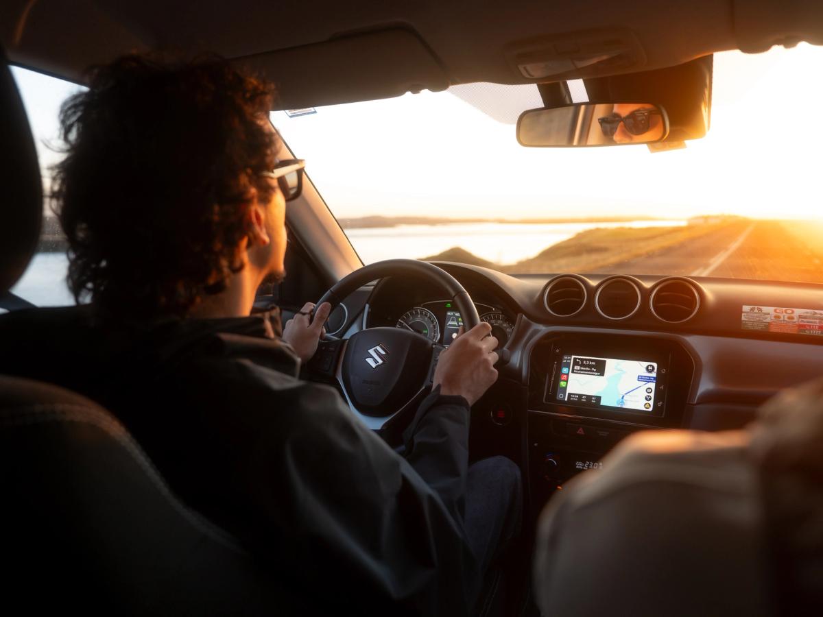 Vue de l’intérieur du Vitara en conduite Vue intérieure d’un Suzuki Vitara avec le conducteur au volant et l’écran de navigation allumé