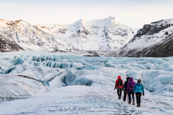 a group of people walking on a glacier