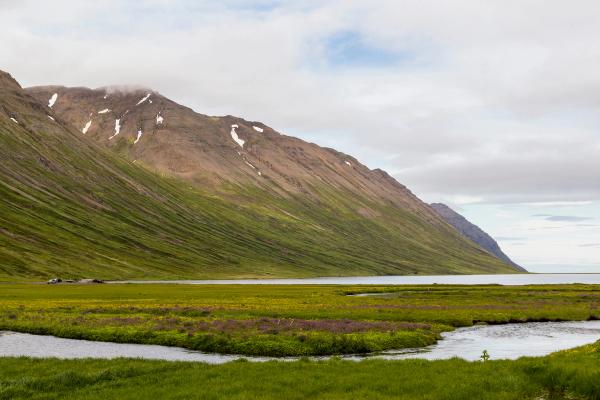 un río con el mar y montañas al fondo