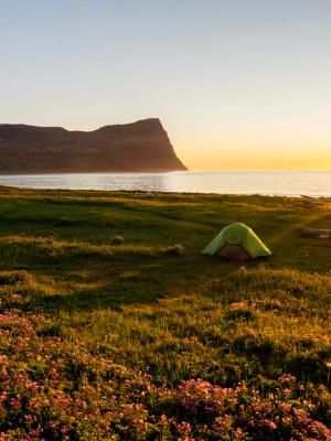 Persona acampando en Islandia bajo el Sol de Medianoche