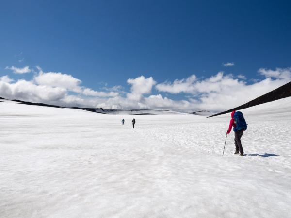 Hikers atravensando un camino cubierto de nieve sobre el Volcán Eyafjallajökull en mitad del sendero Fimmvorduhals
