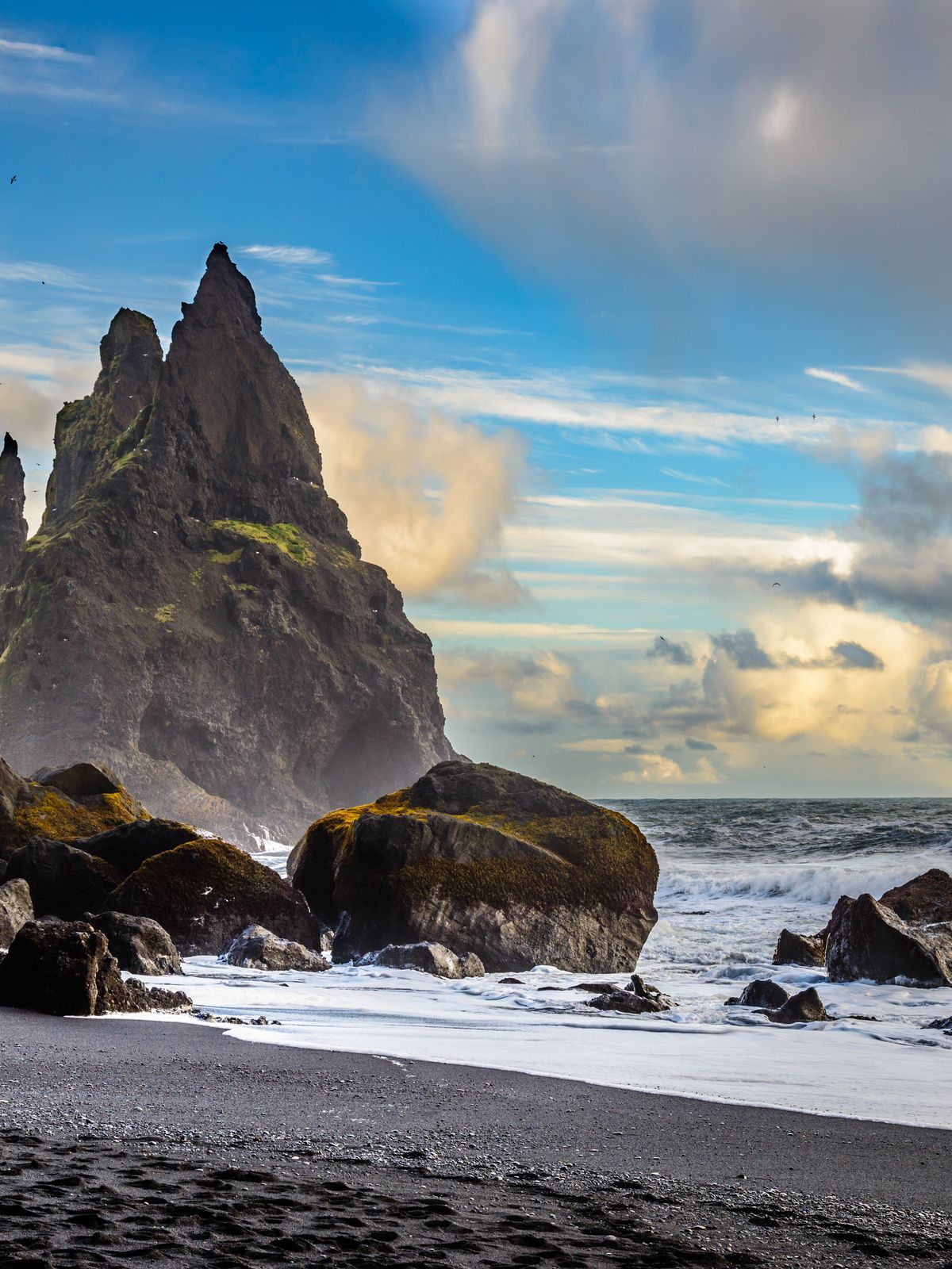 there are a lot of rocks on the beach and in the ocean .