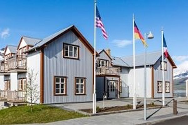 a group of houses with flags flying in front of them. French museum Iceland.