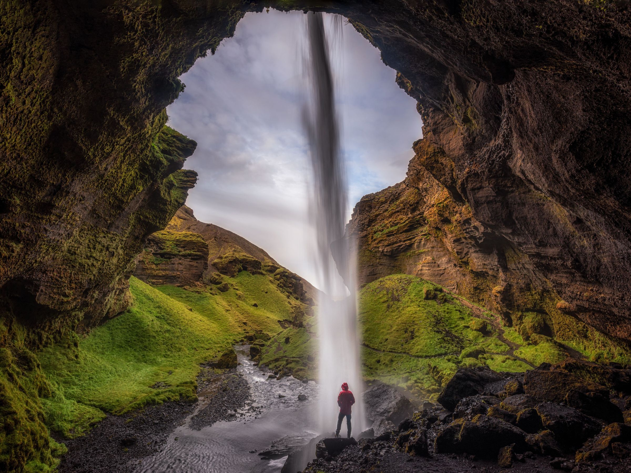 Homme se tenant derrière une cascade