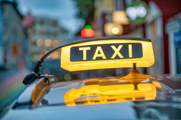 a close up of a taxi sign on the roof of a car .