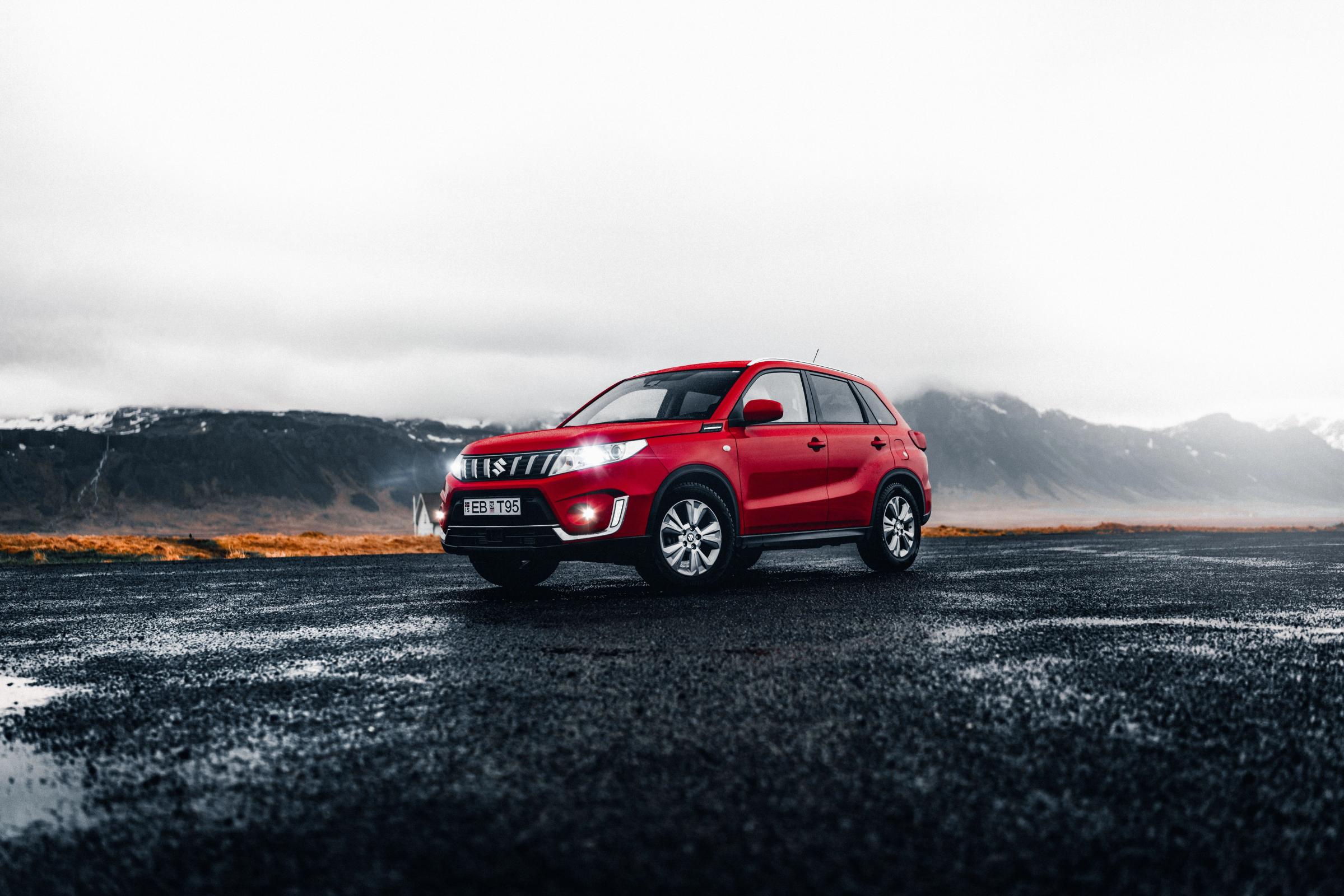 red 4x4 suzuki vitara rental car parked in Iceland