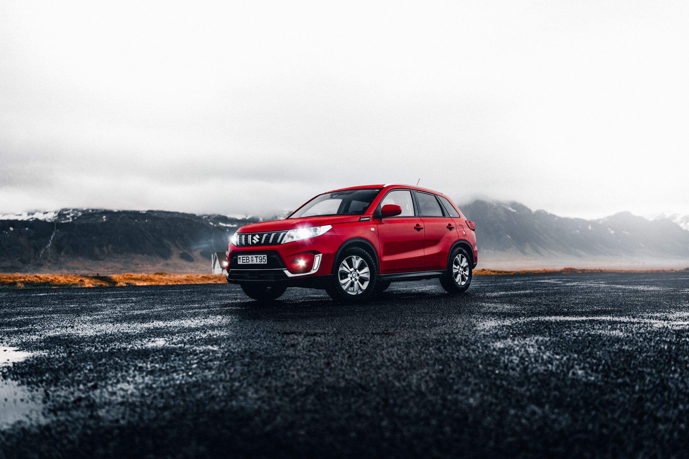 Suzuki Vitara car rental iceland red 4x4 suzuki vitara rental car parked in Iceland