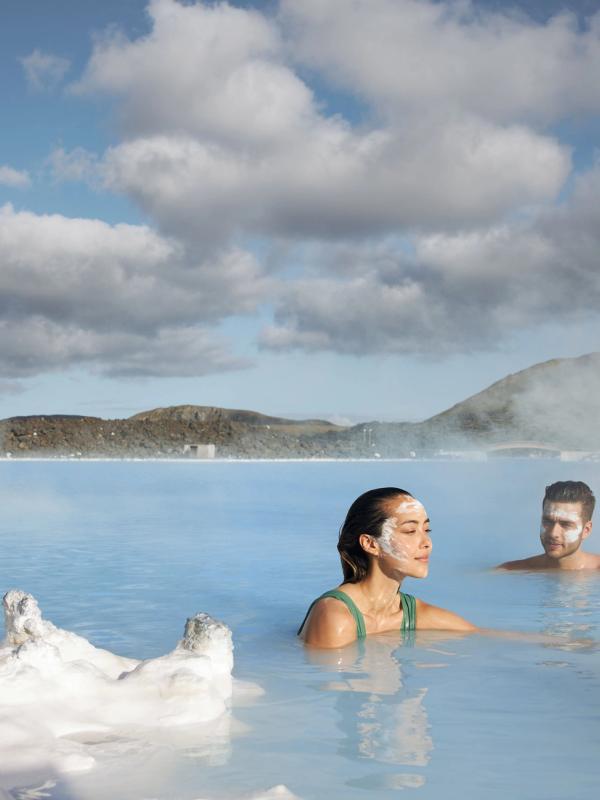 Guide to Visiting Blue Lagoon in Iceland Man and a woman with a face max in blue lagoon hot spring in Iceland
