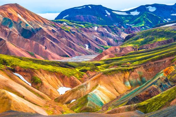 a colorful mountain landscape with a river running through it at Landmannalaugar in Iceland.