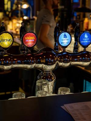 Six illuminated beer taps with "Viking" and "Einstok" branding line a bar.