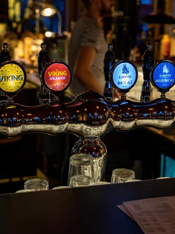 Six illuminated beer taps with "Viking" and "Einstok" branding line a bar.