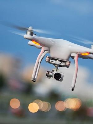 a drone is flying in the sky over a city .