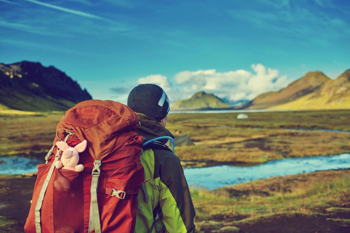 Chico con una backpack roja en Islandia