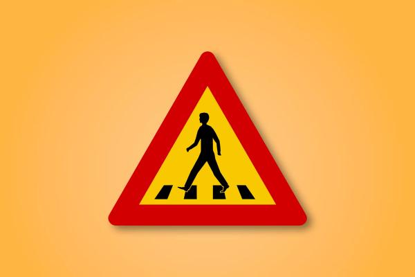 a yellow and red triangle sign with a man walking on a crosswalk .
