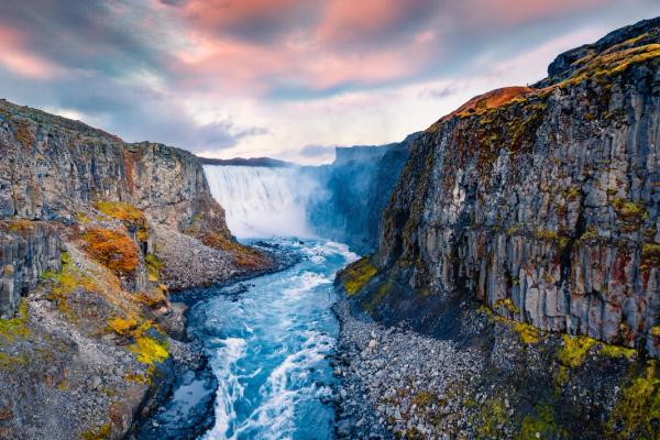 an aerial view of a waterfall in the middle of a canyon at jokulsargljufur in iceland.