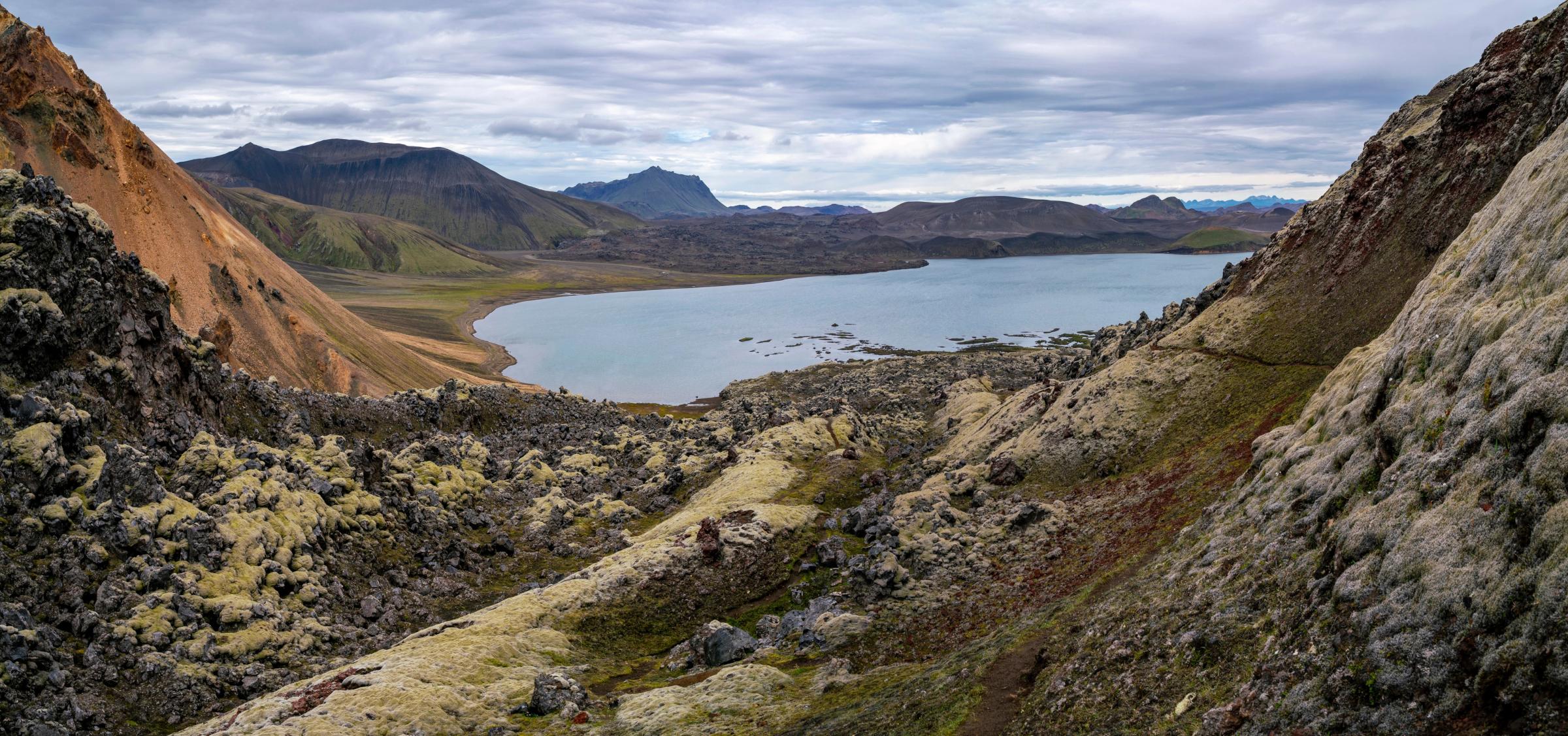 a lake surrounded by mountains and rocks in the middle of a valley .