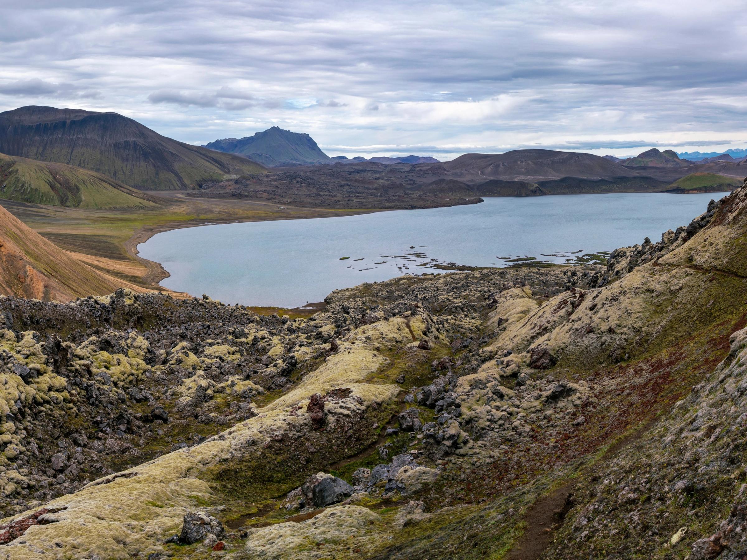 a lake surrounded by mountains and rocks in the middle of a valley .