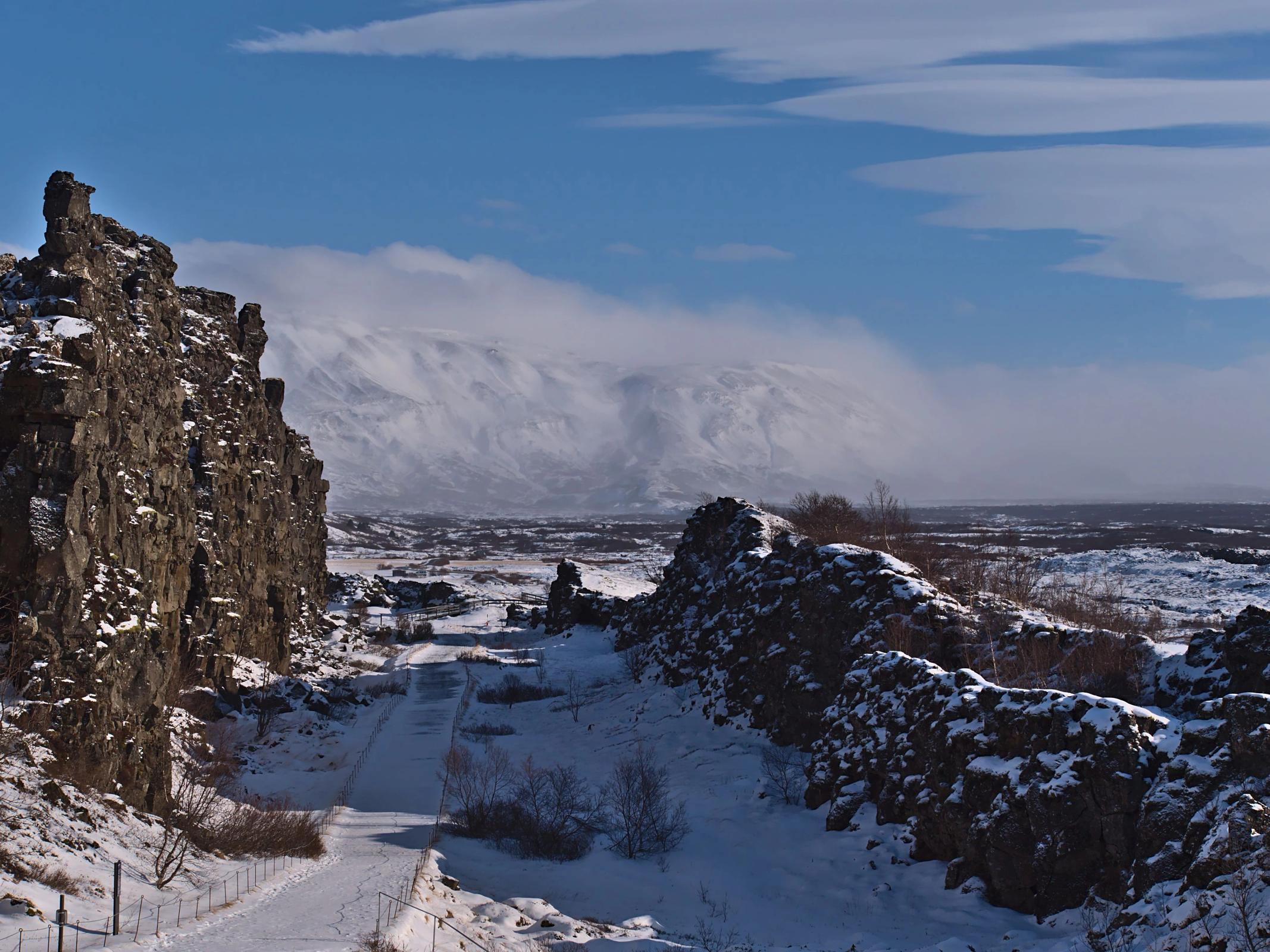 a snowy landscape with mountains in the background and a road in the foreground .