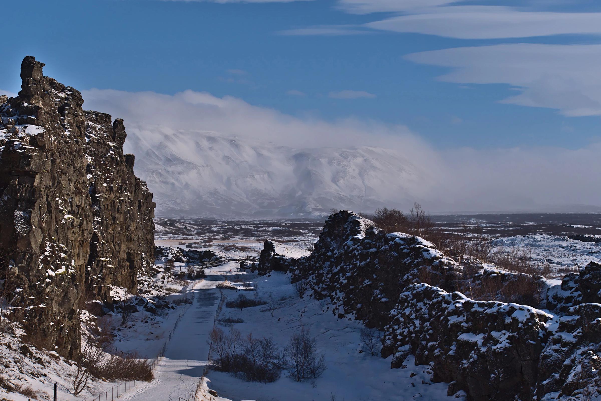 a snowy landscape with mountains in the background and a road in the foreground .