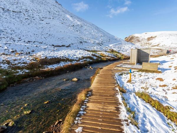 paisaje nevado con un río corriendo entre dos montañas