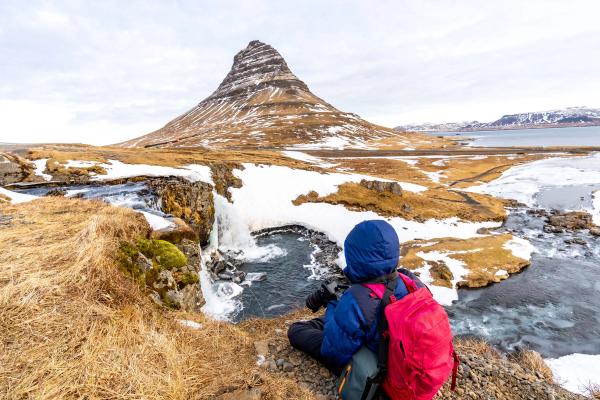 a person taking pictures of Kirkjufell mountain