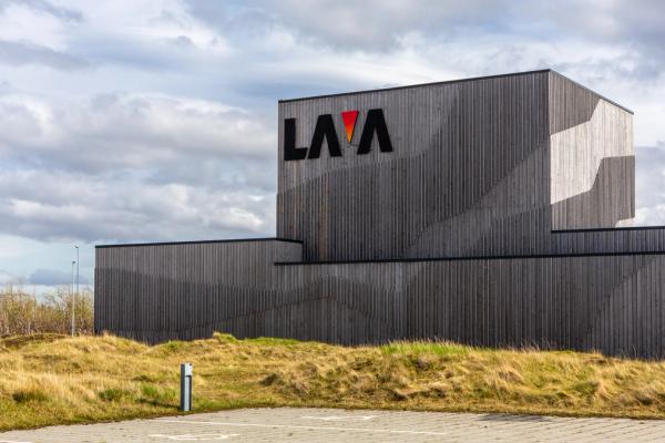 Wooden-paneled building with 'LAVA' logo, grassy foreground, cloudy sky.