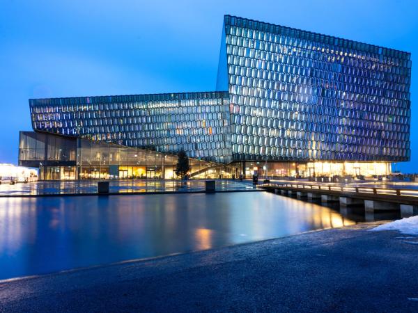 a large building with a lot of windows is sitting next to a body of water .