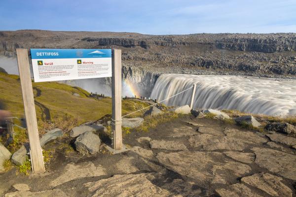 An information sign with a waterfall in the background