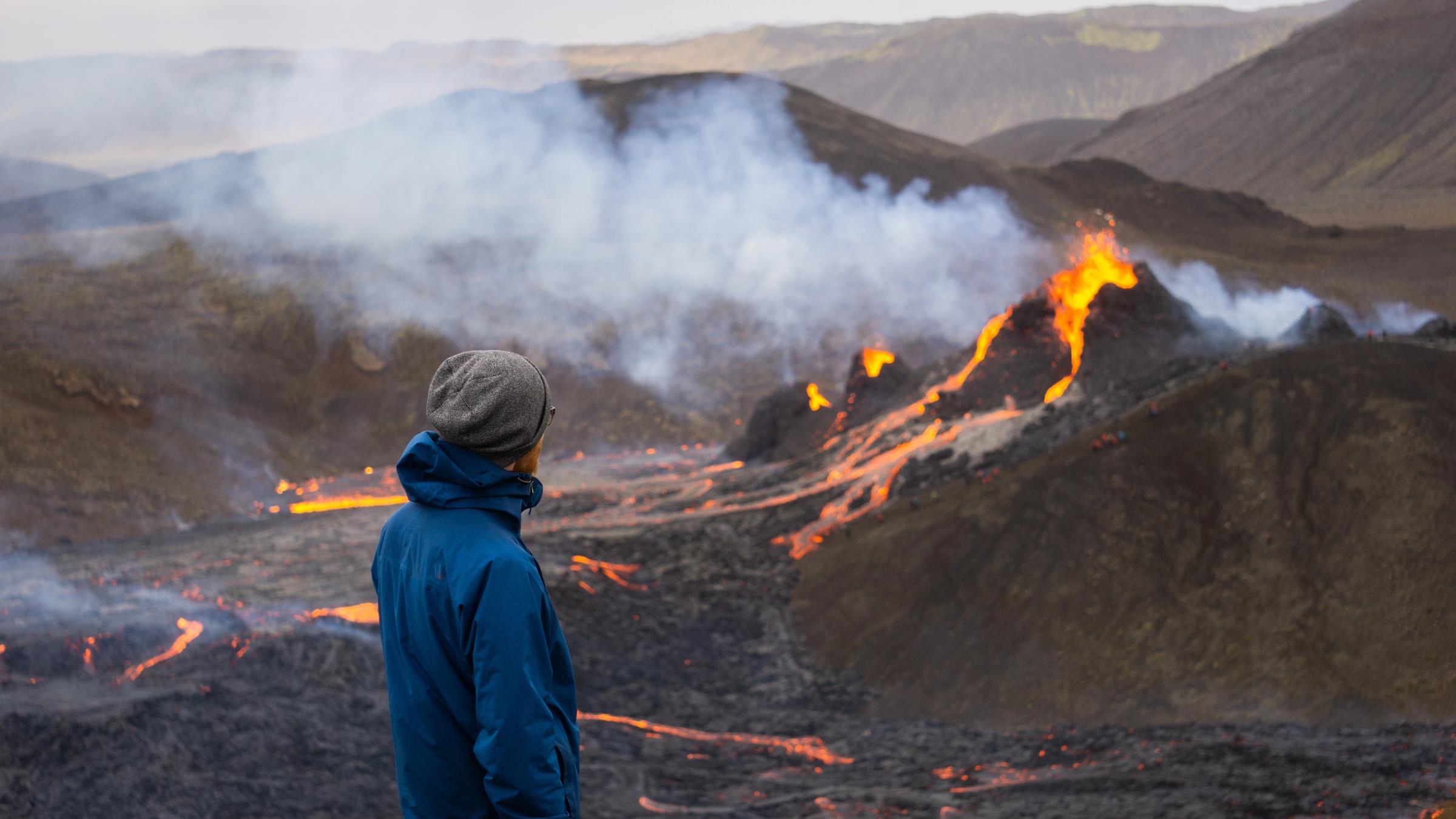 una persona admirando un volcán en erupción