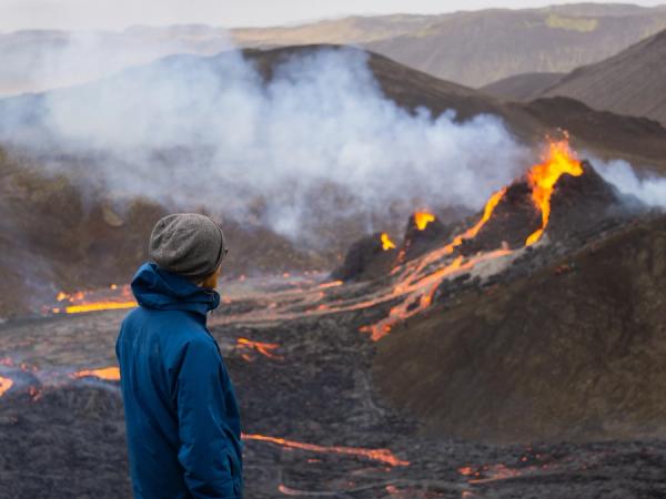 una persona admirando un volcán en erupción