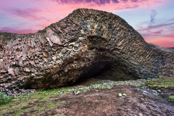 a large rock formation with a cave in the middle of it .